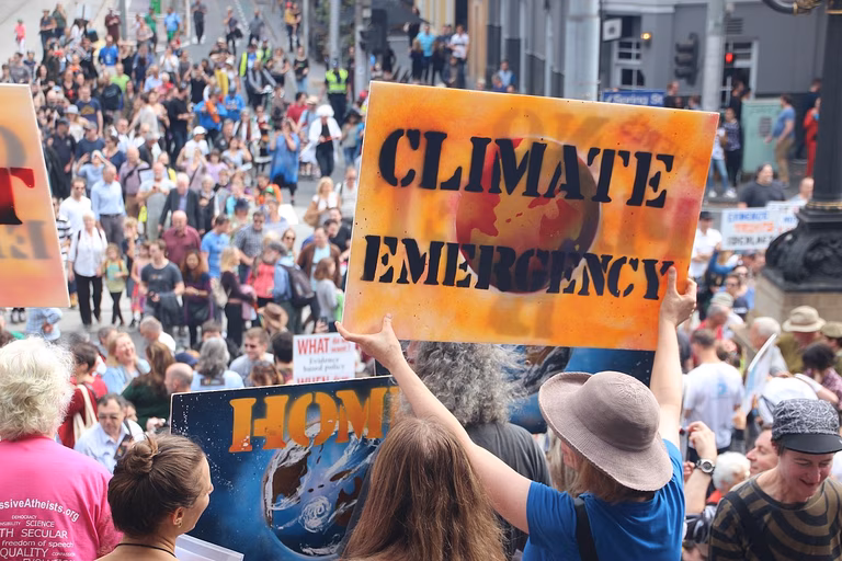 Thousands of Melburnians turned up and marched for science on April 22, Earthday 2017. In the foreground of the image there a large organe sign which says 'Climate Emergency'