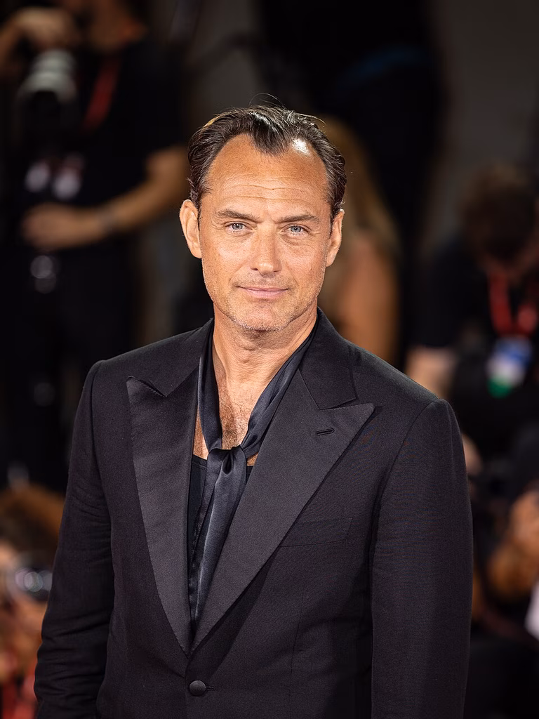 Image of actor and philanthropist Jude Law wearing a black suit at the Venice Film Festival in 2024.