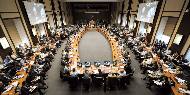 After Chicago: Re-evaluating NATO's priorities - NATO Meeting in Brussels on May 25, 2012. You see a large room filled with people with a huge table in the middle