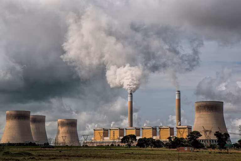 A powerplant with four huge towers send clouds of vapour and smoke into the sky.